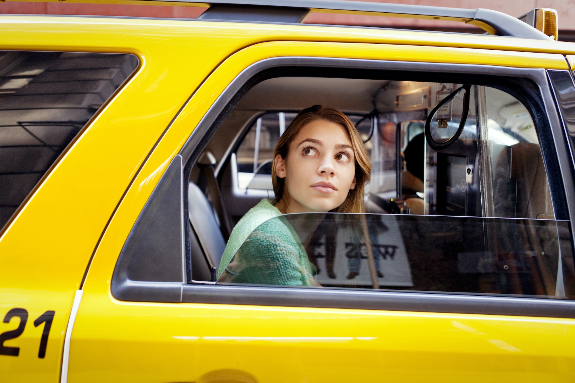 Woman Looking Through Window While Sitting In Taxi At City